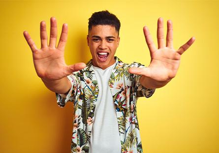 student wearing tshirt and aloha shirt holding up hands with 10 fingers