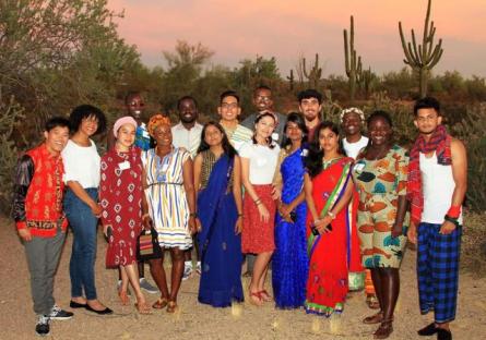 A diverse group of International Exchange students posing for a photo in the desert.