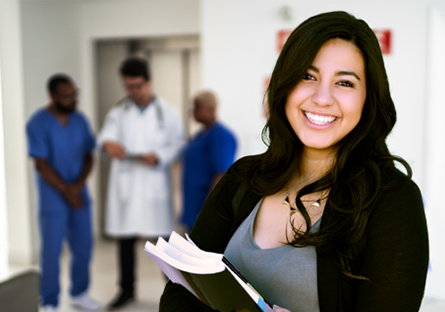 student carrying books with backdrop of medical instructors