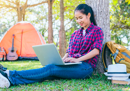 female with laptop in campground
