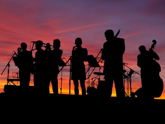 jazz ensemble silhouette with a desert sunset background 