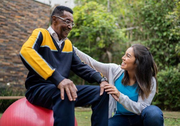 A young woman talking to an elderly man as a community health work program